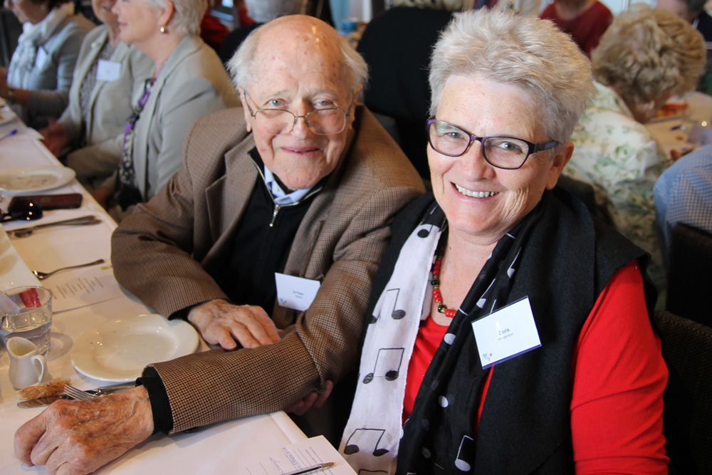 A man and woman sitting at a table at an event for the WCH Foundation.