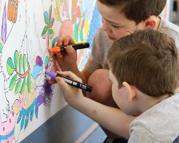 Young patients Declan and Connor colouring in a hospital mural.
