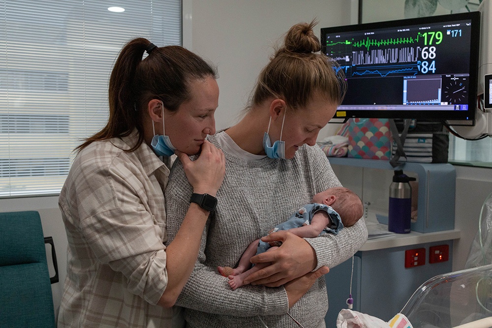 Megan and Jess admiring their beautiful newborn Rylee. 