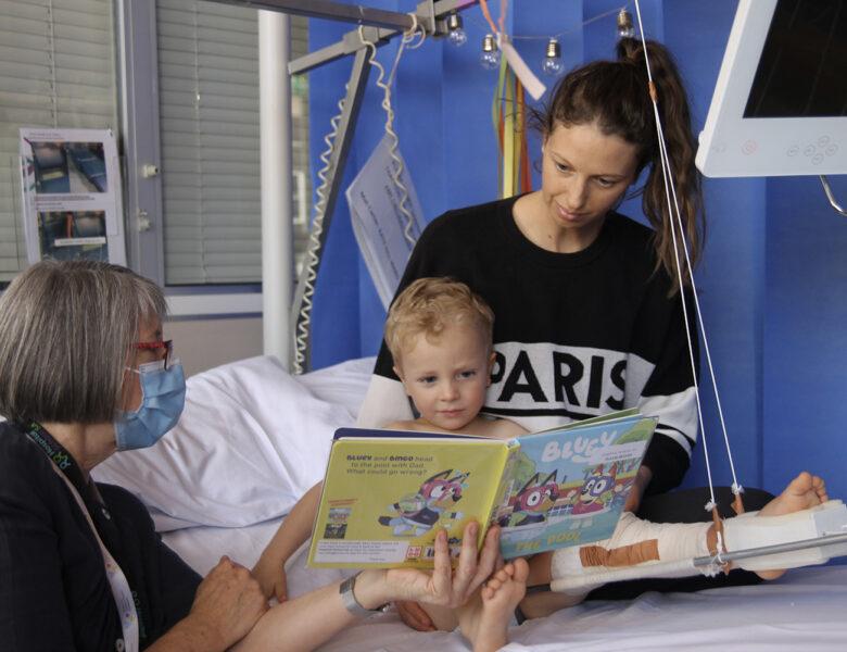 Three year old Theor in Hospital with his Mum and Book Buddy Chris.