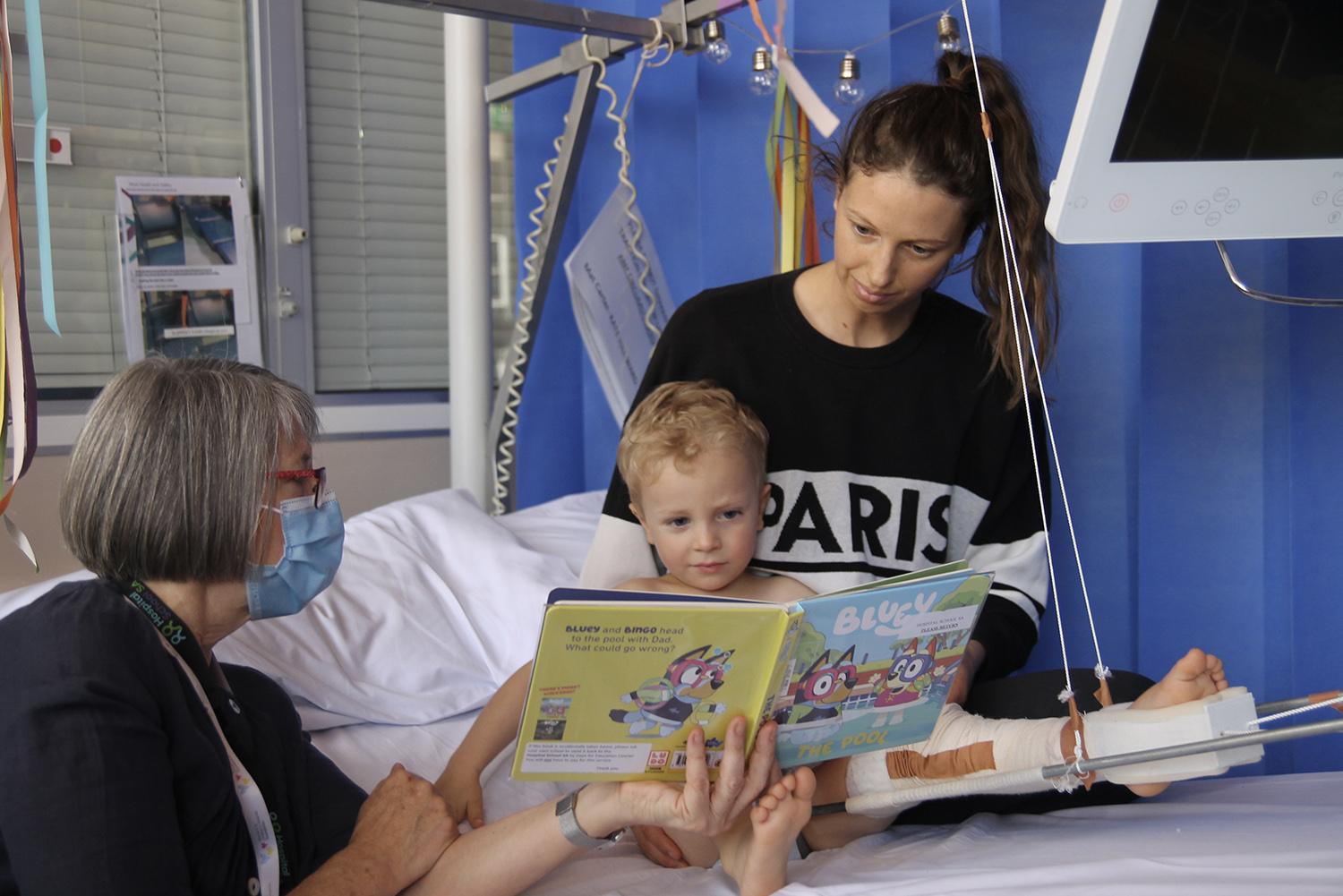 Three year old Theor in Hospital with his Mum and Book Buddy Chris.