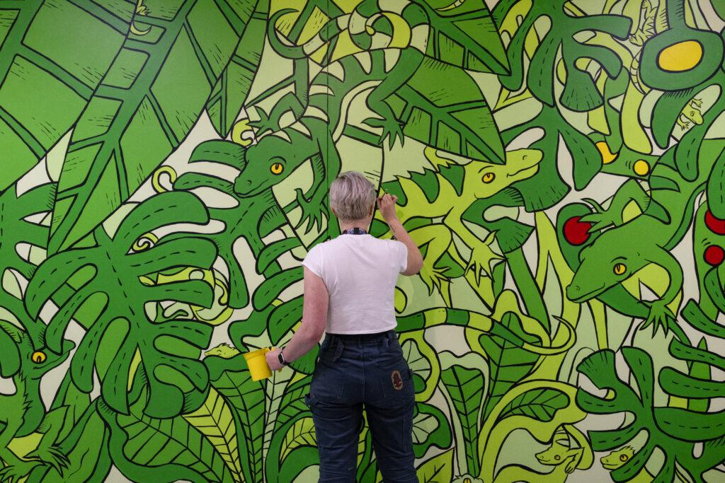 Wen painting the green mural public art. 